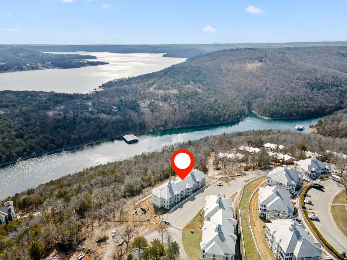 An aerial view of the lake, rolling hills, and the neighborhood layout, with the highlighted property visible. The image shows the proximity to nature and walking trails, emphasizing access to boating, hiking, and nature walks. The peaceful, inviting atmosphere is enhanced by the colors of the sunset and open spaces that encourage exploration.